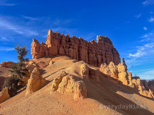 A view of the steep hillside with several hoodoos on it leading towards the shady backside of the Golden Wall. I especially liked the small hoodoo to the far right of the wall that has a ball perched on a tiny pedestal.